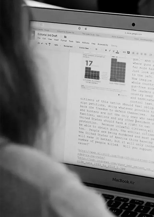 A MacBook Air laptop displaying a Google Docs document with a chart showing 17 in one column and a grid of text discussing gun rights and legislation.